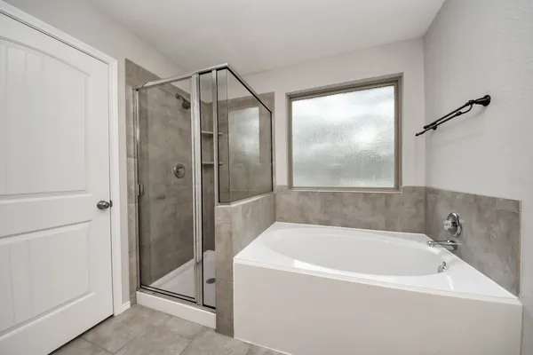 a spacious bathroom with a bathtub shower sink double vanity and mirror