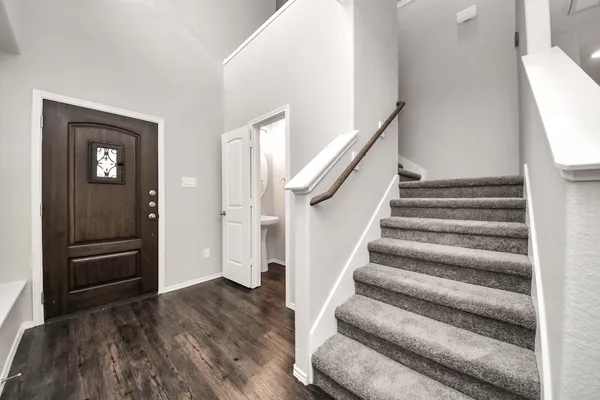 a view of an empty room with a kitchen and a window