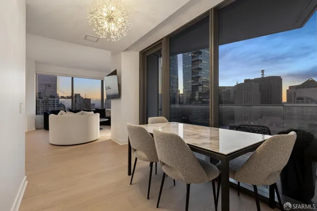 a dining room with furniture a chandelier and wooden floor