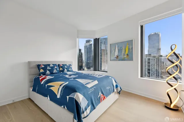 a view of a balcony with a couple of cars parked in front of buildings