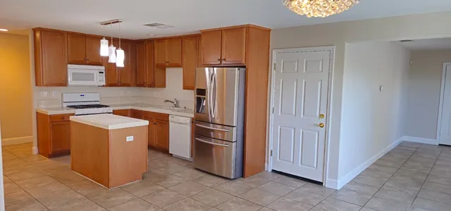 a kitchen with a refrigerator sink and cabinets
