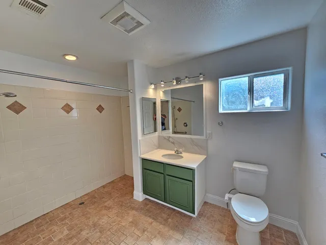 a bathroom with a toilet sink and mirror