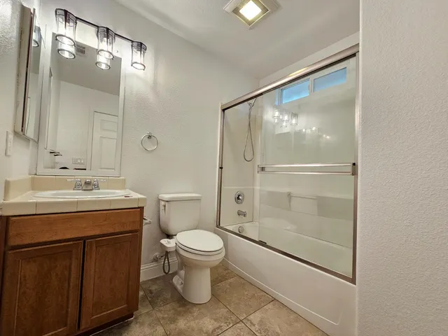 a bathroom with a granite countertop sink toilet and shower