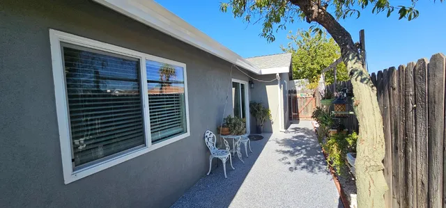 a view of a porch with plants and floor to ceiling window