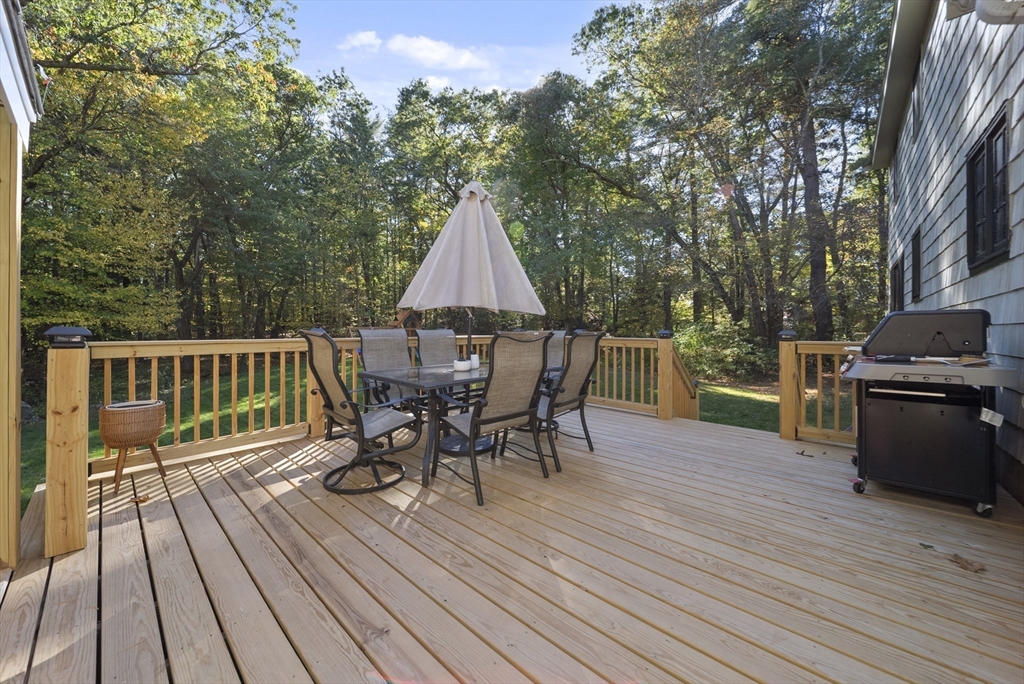 41 Searle Street Georgetown, MA 01833 - Photo 17 of 26 a view of a roof deck with table and chairs a barbeque with wooden floor and fence