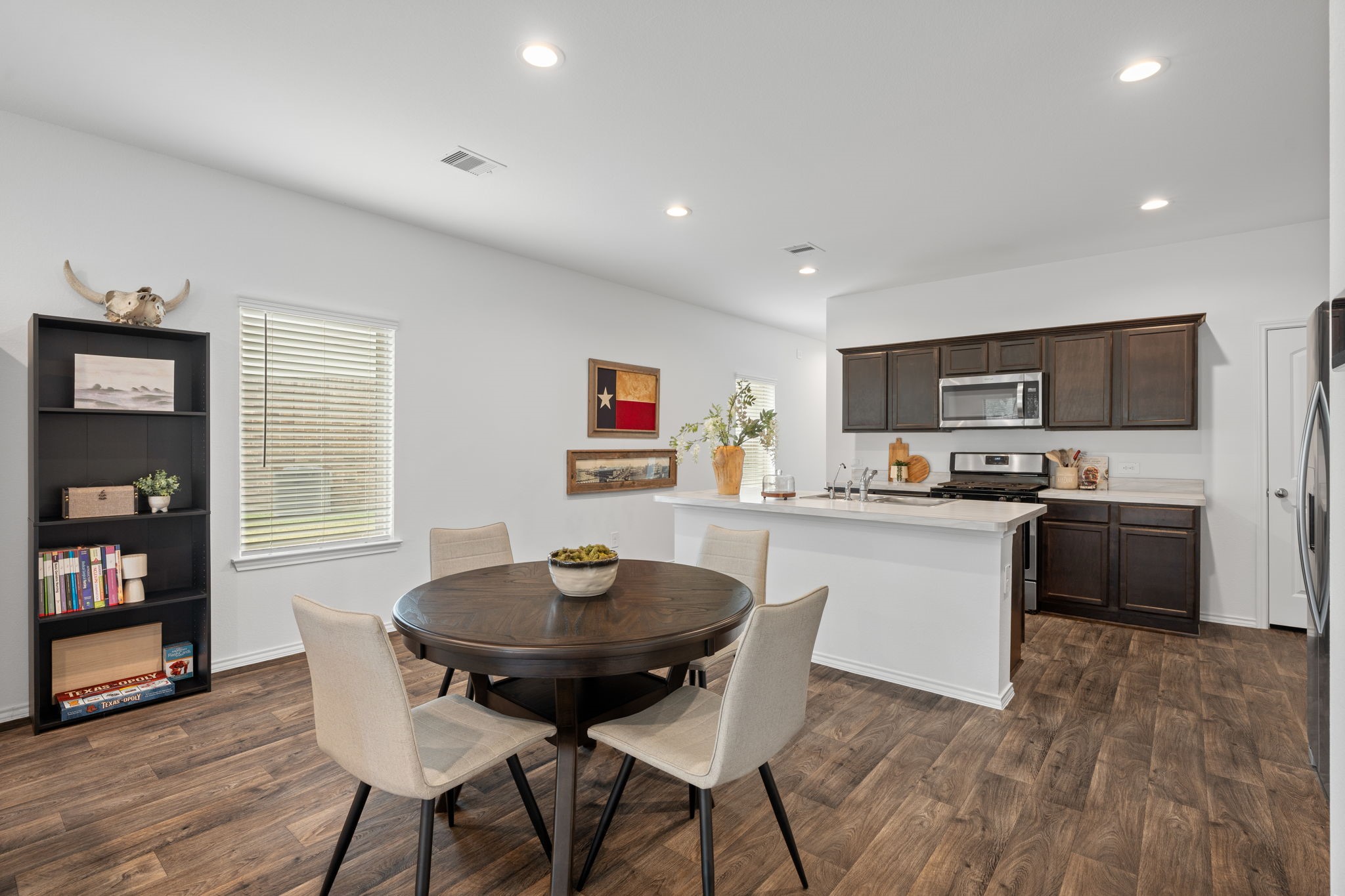 22306 Forest Gorge Lane Spring, TX 77373 - Photo 9 of 26 a kitchen with a dining table chairs and refrigerator