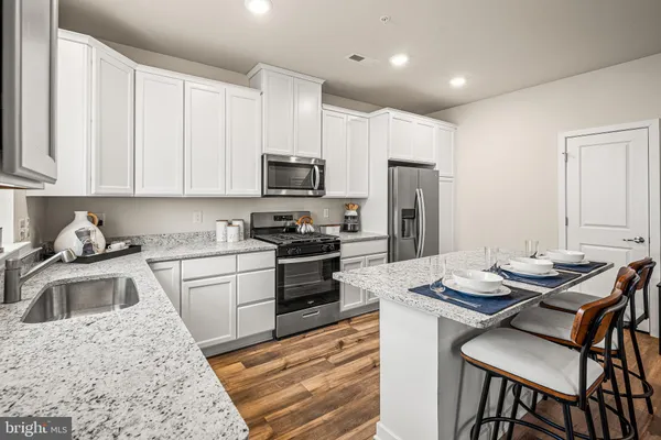 a kitchen with a refrigerator stove top oven and sink