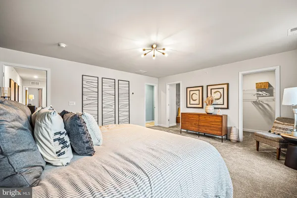 a bedroom with a bed dresser and window