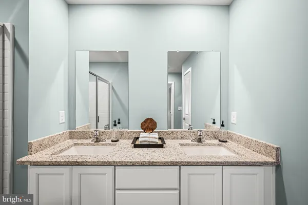 a bathroom with double sink and a mirror