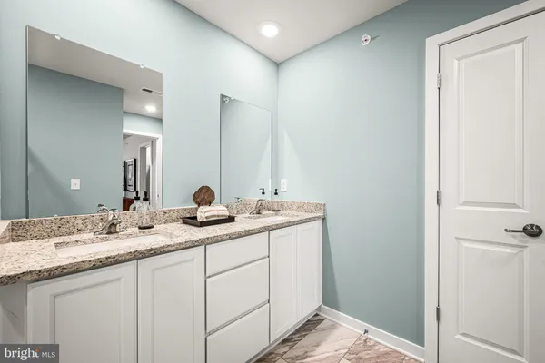 a bathroom with a double vanity sink and mirror