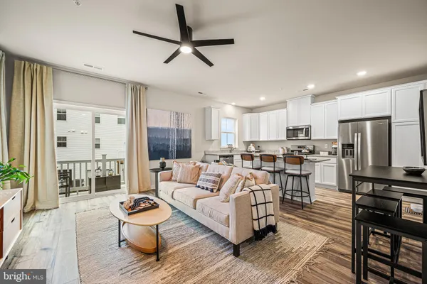a living room with furniture kitchen view and a refrigerator