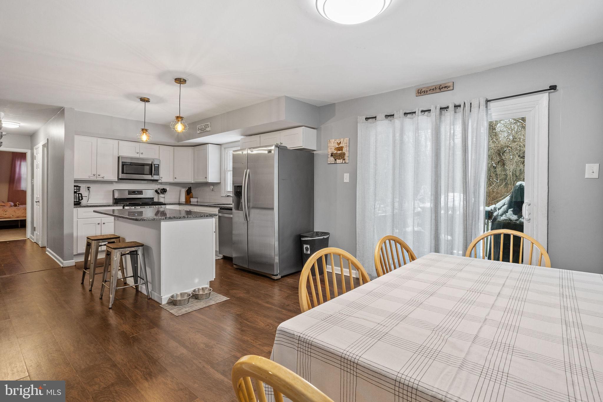 1 Ruby Avenue Sewell, NJ 08080 - Photo 13 of 32 a large kitchen with kitchen island a refrigerator a stove a sink dishwasher a dining table and chairs with wooden floor