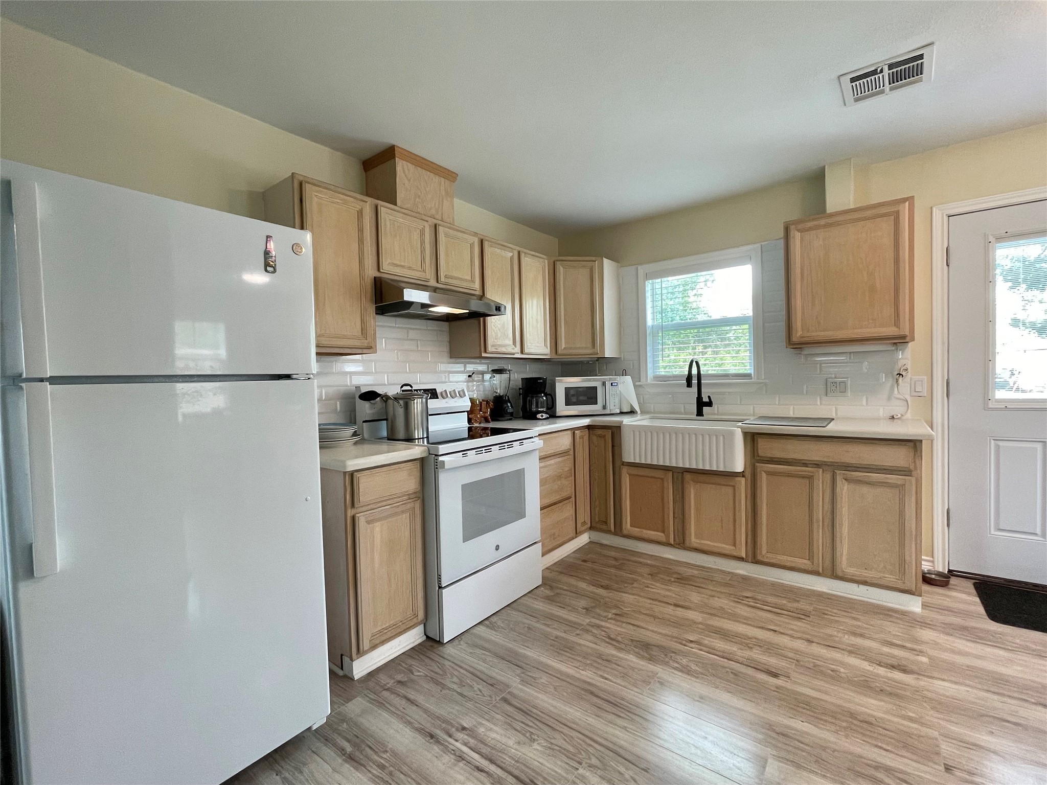 1116 Lake Street Clute, TX 77531 - Photo 12 of 34 a kitchen with white cabinets and white appliances