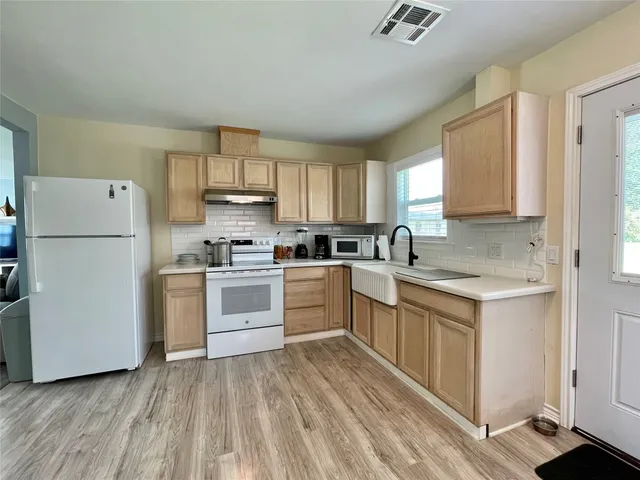 a kitchen with white cabinets and white appliances