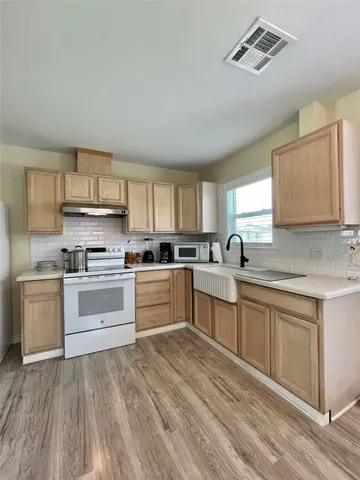 a kitchen with granite countertop white cabinets and white appliances