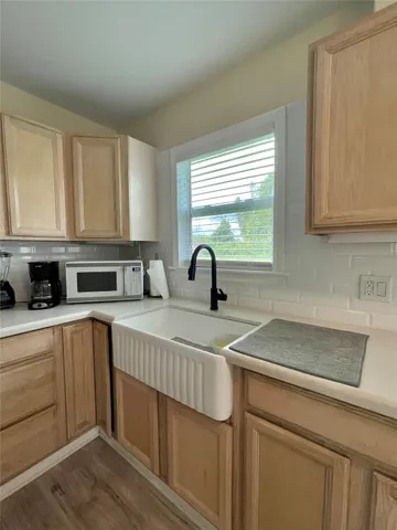 a kitchen with stainless steel appliances granite countertop a sink a stove and white cabinets with wooden floor