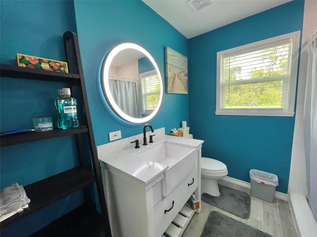 a bathroom with a toilet sink and mirror
