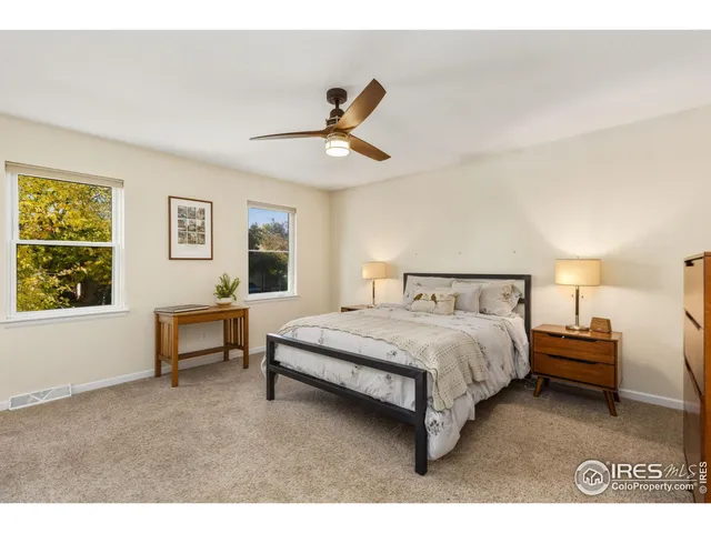 a spacious bedroom with a bed and a chandelier