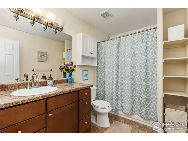 a bathroom with a granite countertop sink toilet and shower
