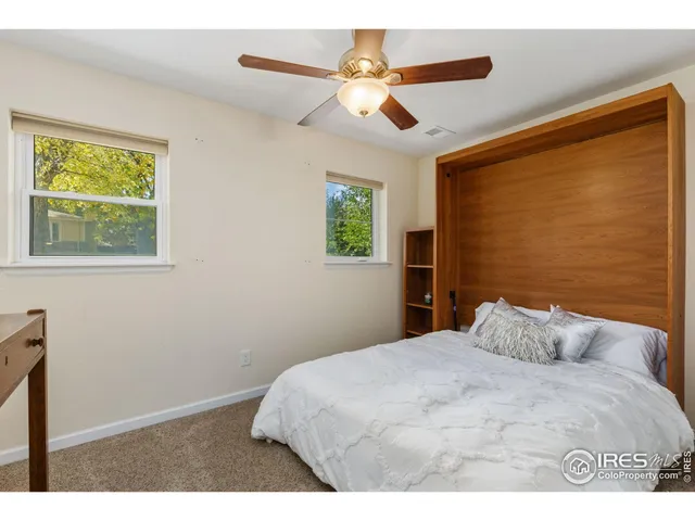 a bedroom with a large bed and a ceiling fan