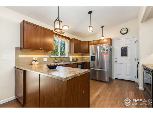 a kitchen with stainless steel appliances a refrigerator a sink a stove a microwave and wooden floor
