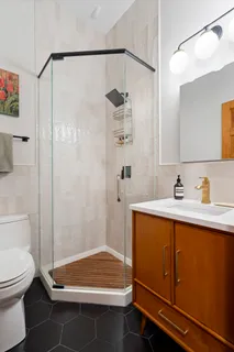 a bathroom with a sink a toilet and shower