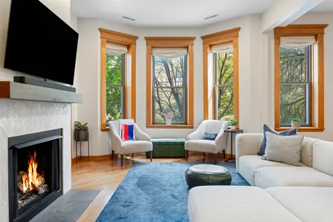 a living room with furniture a flat screen tv and a fireplace