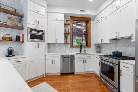 a kitchen with stainless steel appliances granite countertop a stove a sink and a microwave