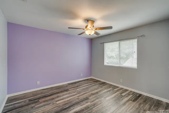 an empty room with a window and a fan