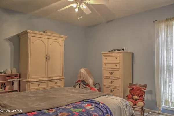 a bedroom with a bed and a wooden floor