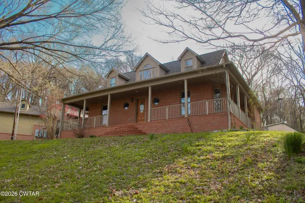 an aerial view of a house with a yard and lake view