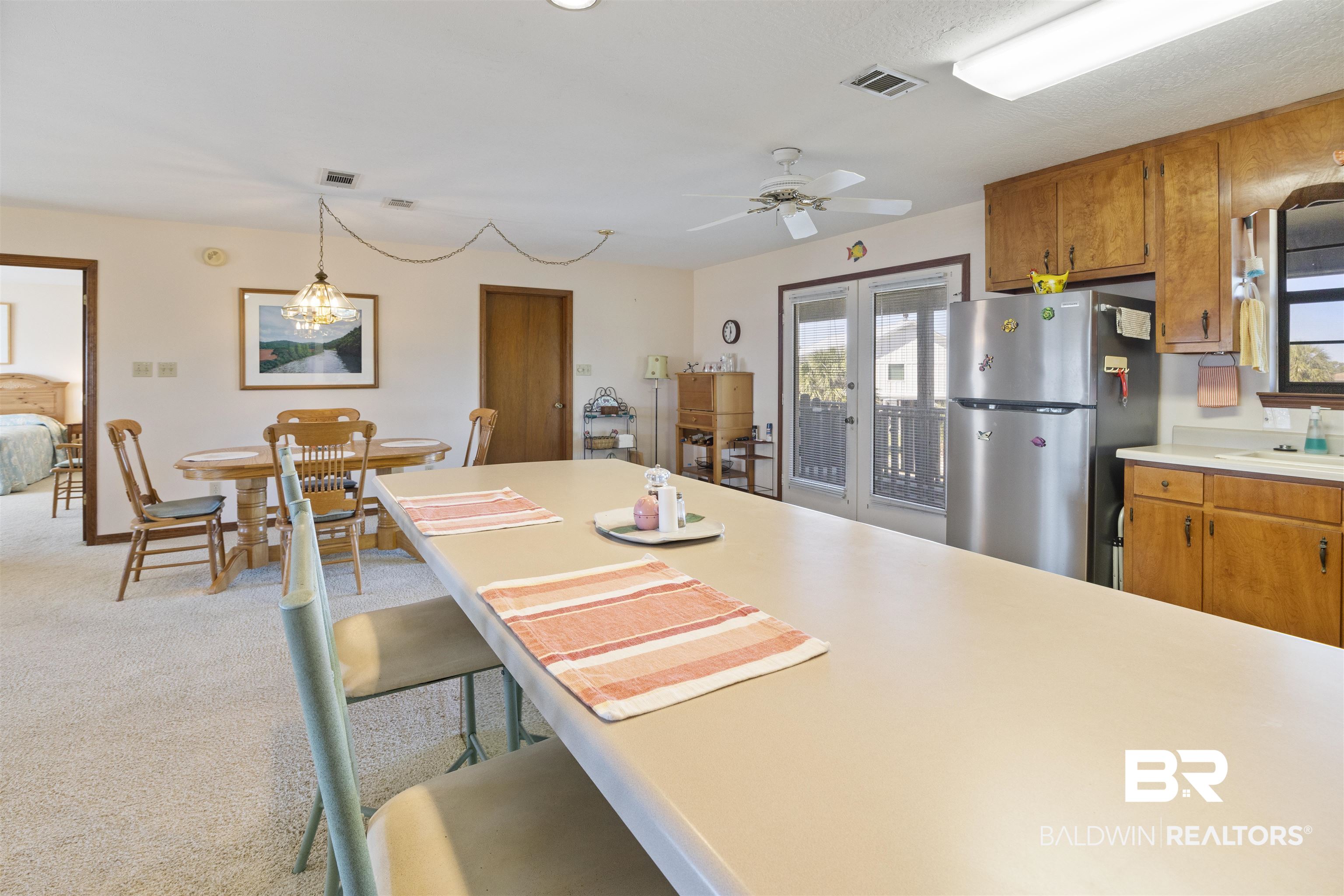 27321 Marina Road Orange Beach, AL 36561 - Photo 20 of 55 Kitchen with french doors, ceiling fan, decorative light fixtures, light carpet, and stainless steel refrigerator