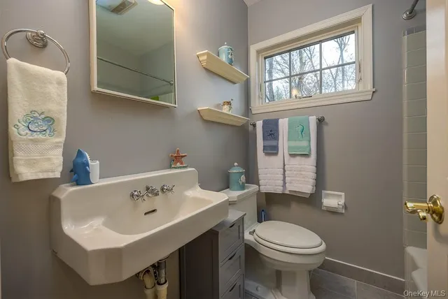 a bathroom with a toilet sink and mirror