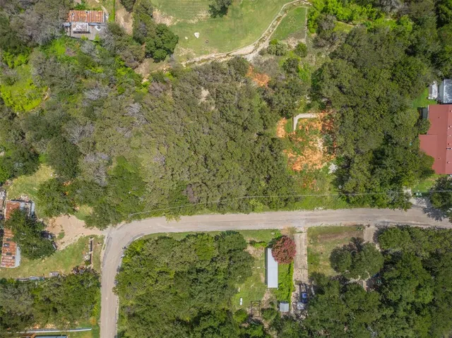 an aerial view of residential house with outdoor space and trees all around