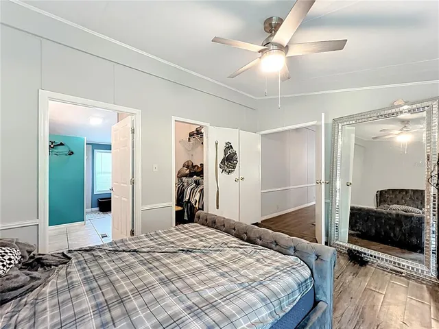 a bedroom with a bed and a large mirror with a flat tv screen