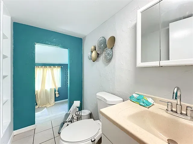 a bathroom with a sink a toilet and mirror