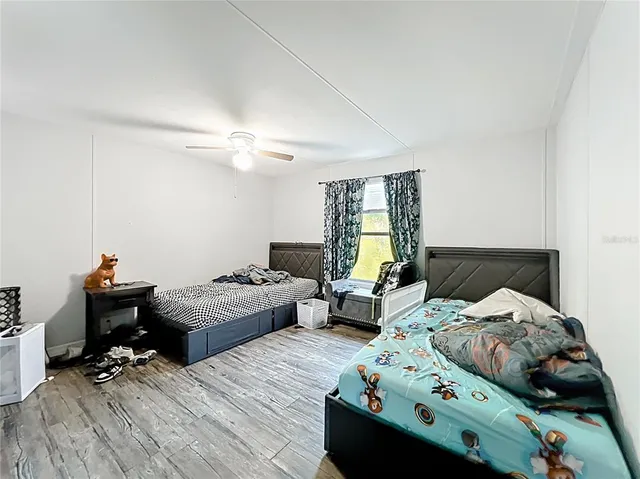 a bedroom with a bed and wooden floor