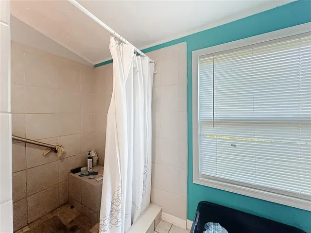 a view of a room that has a window and wooden walls