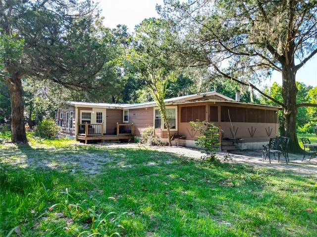 a view of a house with backyard sitting area and garden