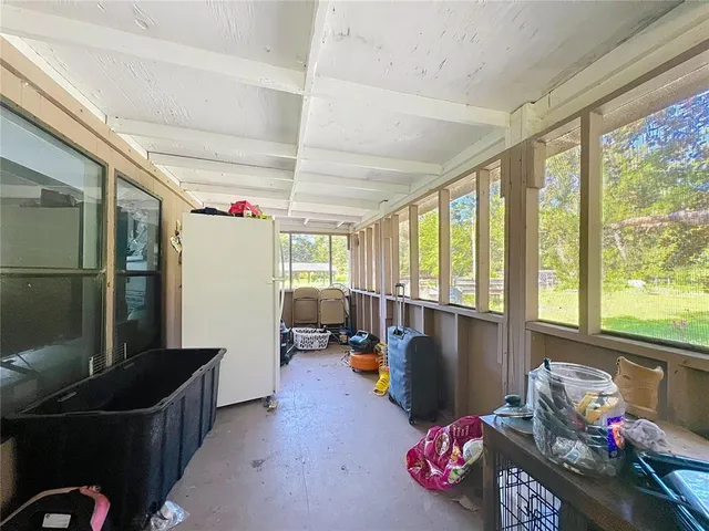 a backyard of a house with table and chairs under an umbrella