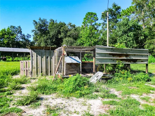 a view of a patio with table and chairs potted plants and large tree