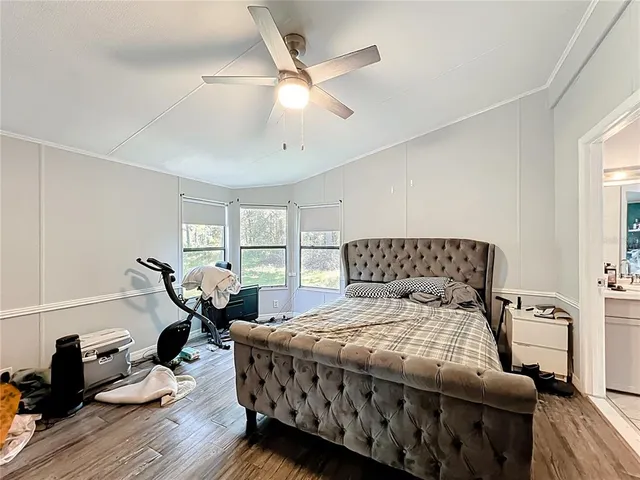 a bedroom with bed and wooden floor