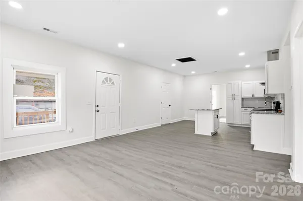 a view of kitchen with refrigerator and white cabinets