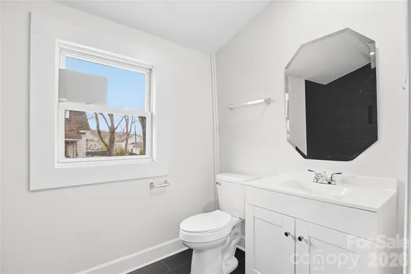 a bathroom with a toilet sink and mirror