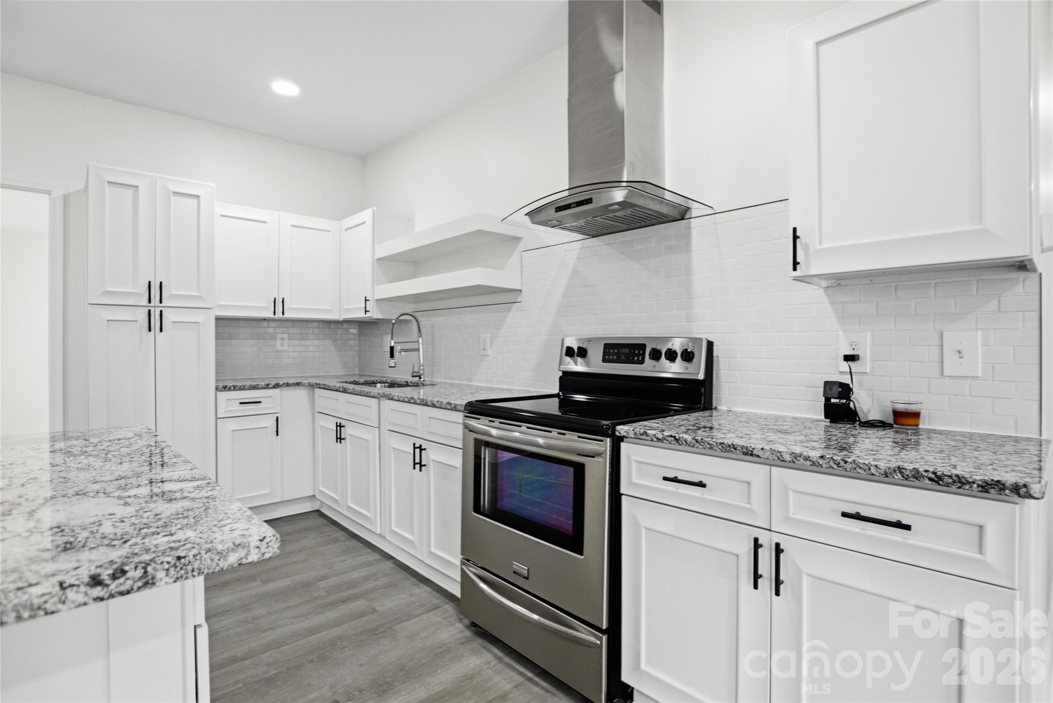706 Sweeney Street Chester, SC 29706 - Photo 6 of 20 a kitchen with granite countertop stainless steel appliances sink stove and cabinets