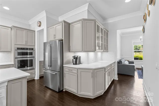a kitchen with stainless steel appliances a refrigerator a sink a stove and cabinets