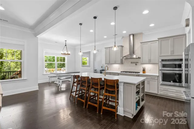 a kitchen with stainless steel appliances a stove a sink a center island and a window