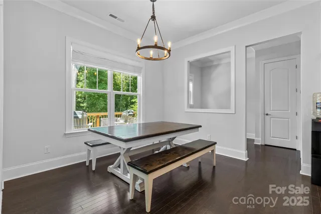 a room with wooden floor a chandelier and a window