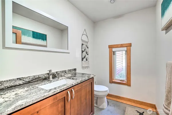 a bathroom with a granite countertop sink and a mirror