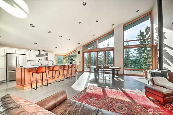 a living room with furniture kitchen view and large windows